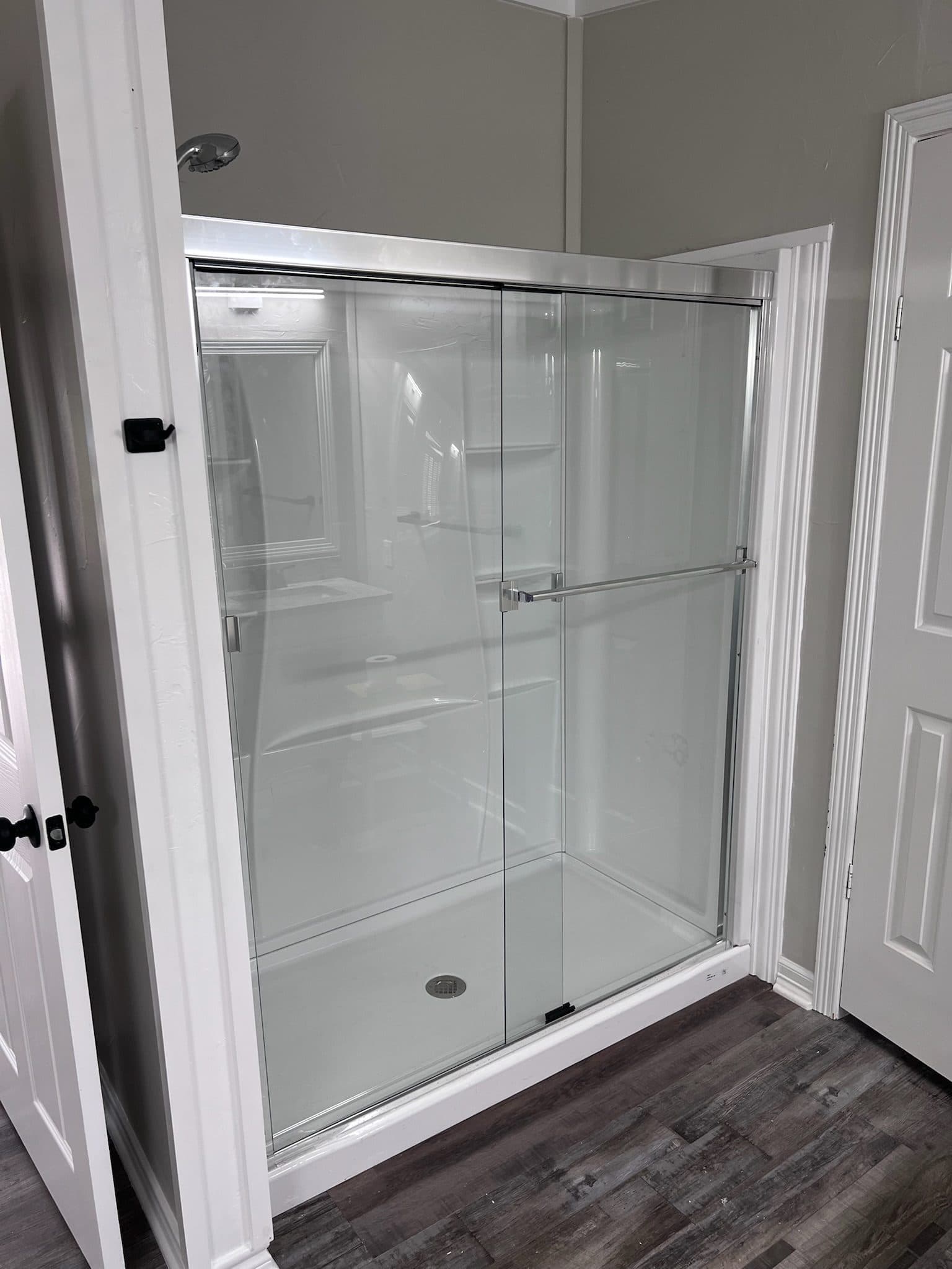 White acrylic shower stall with new clear glass bypass doors