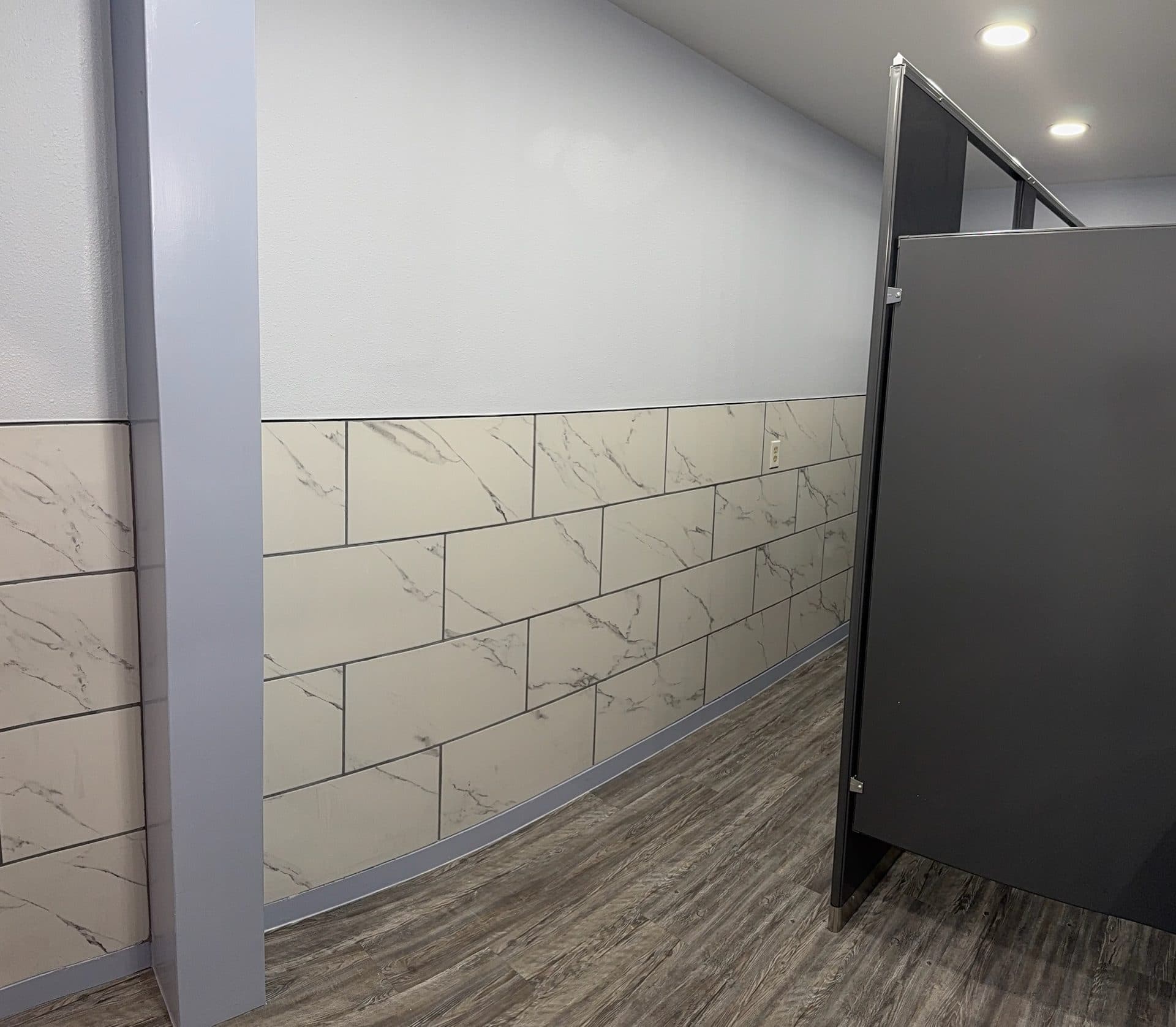 Marble subway tile wainscot in commercial restroom