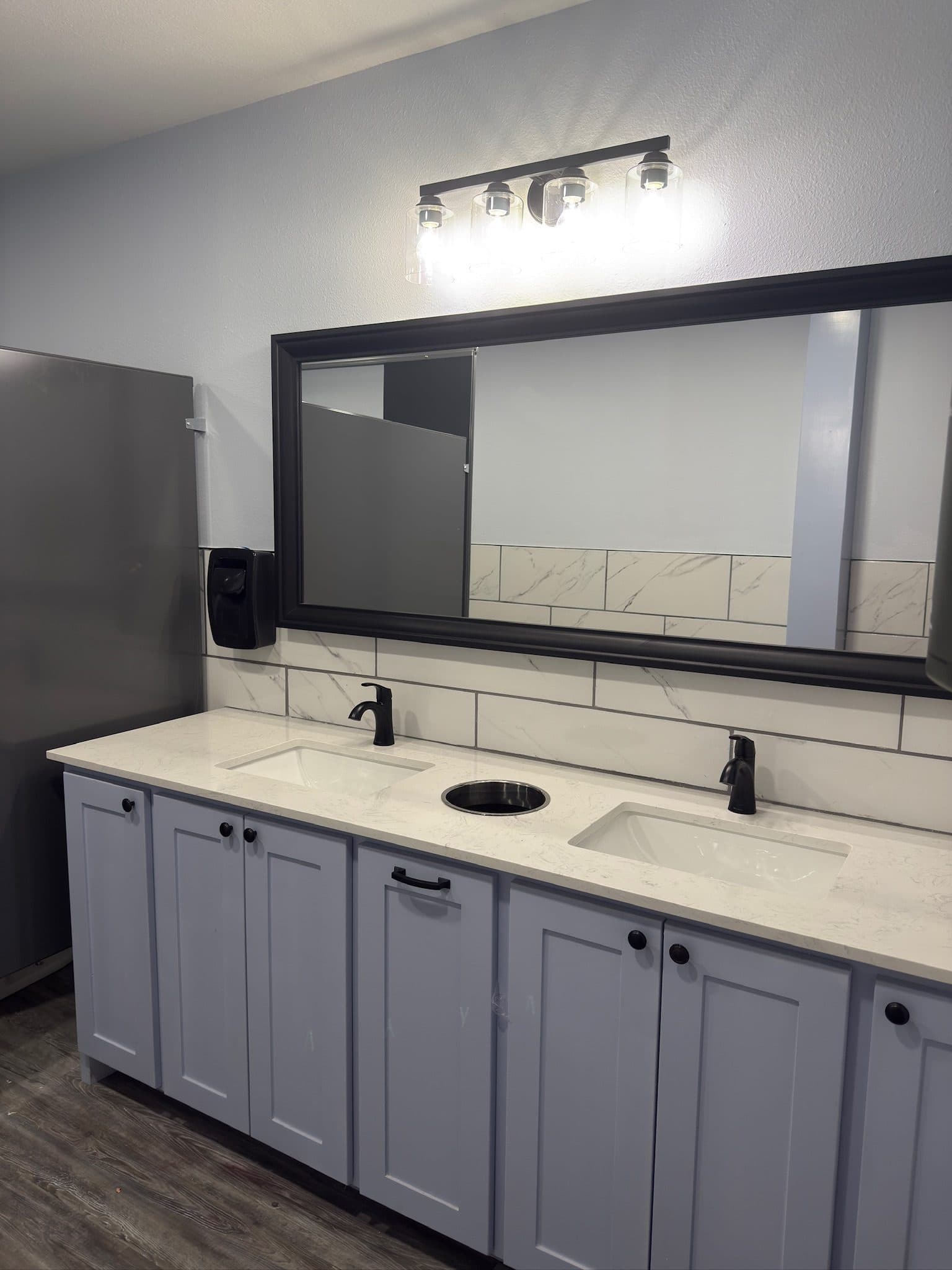 Commercial double vanity with marble subway backsplash and gray shaker cabinets