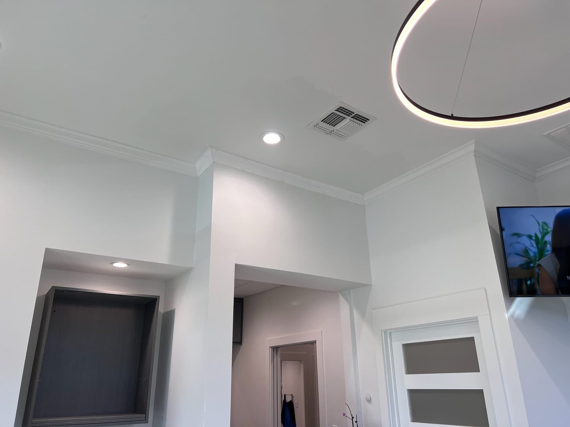 Coffered ceiling with crown molding and modern ring pendant light