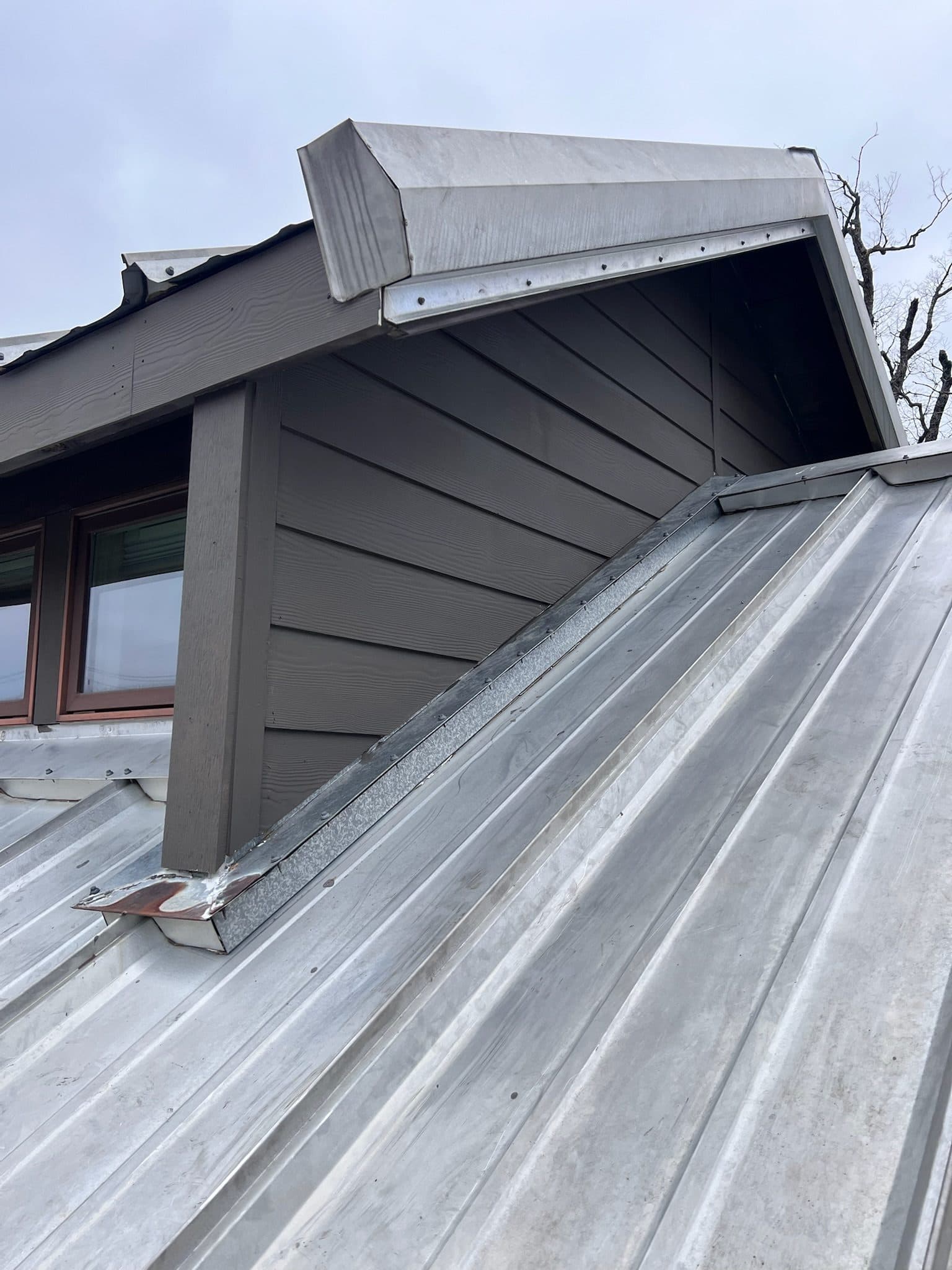 Standing-seam metal roof dormer detail with new flashing