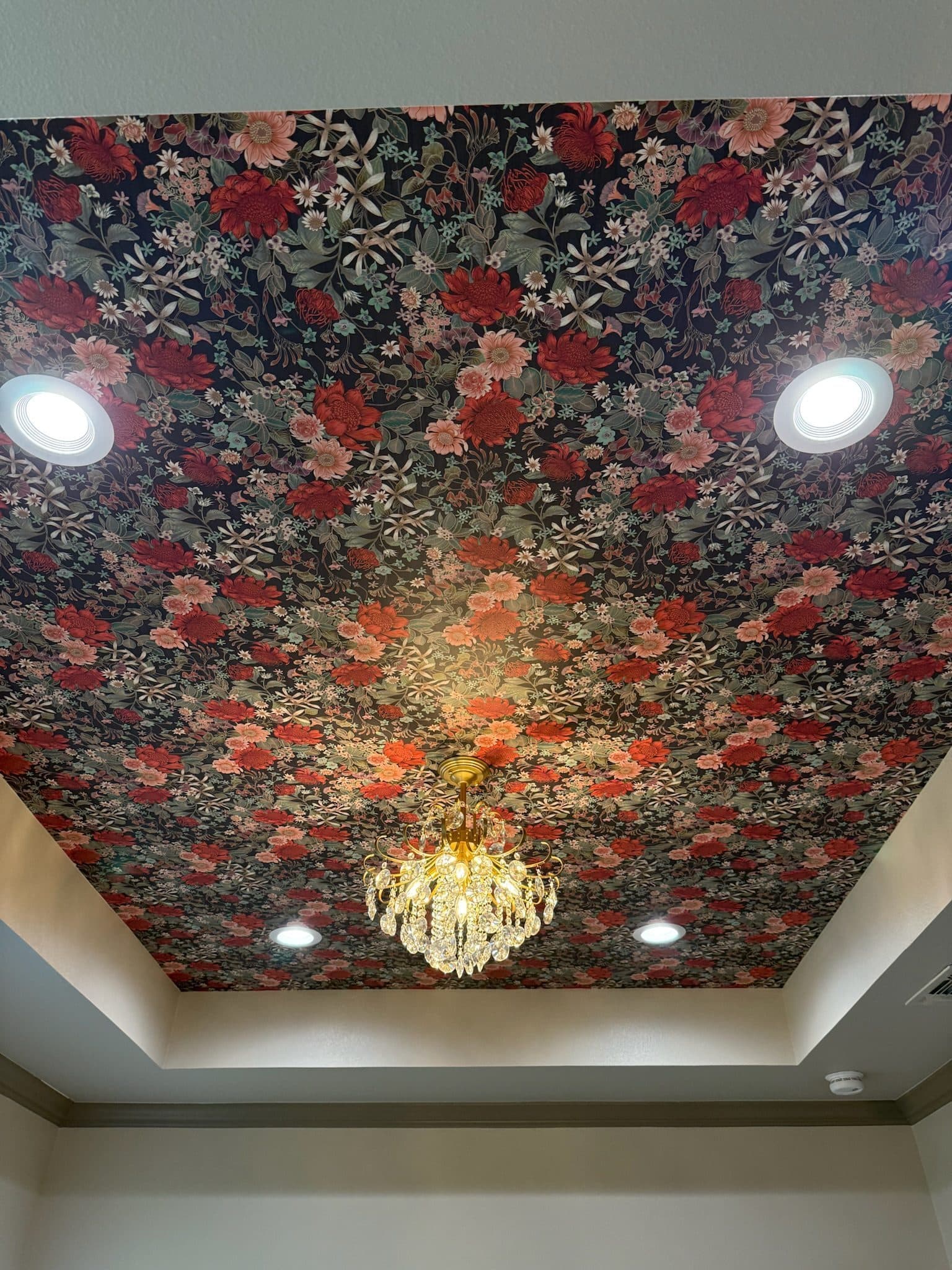 Primary bath floral wallpapered tray ceiling with crystal chandelier