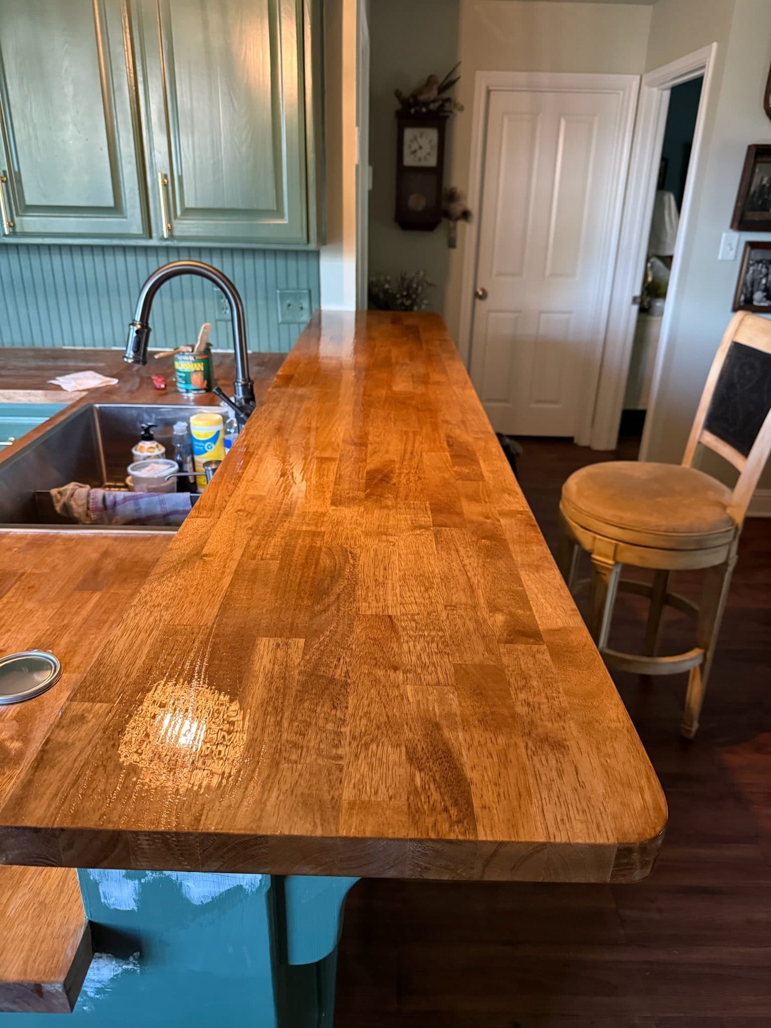 Wide oak butcher block bar top over teal painted island