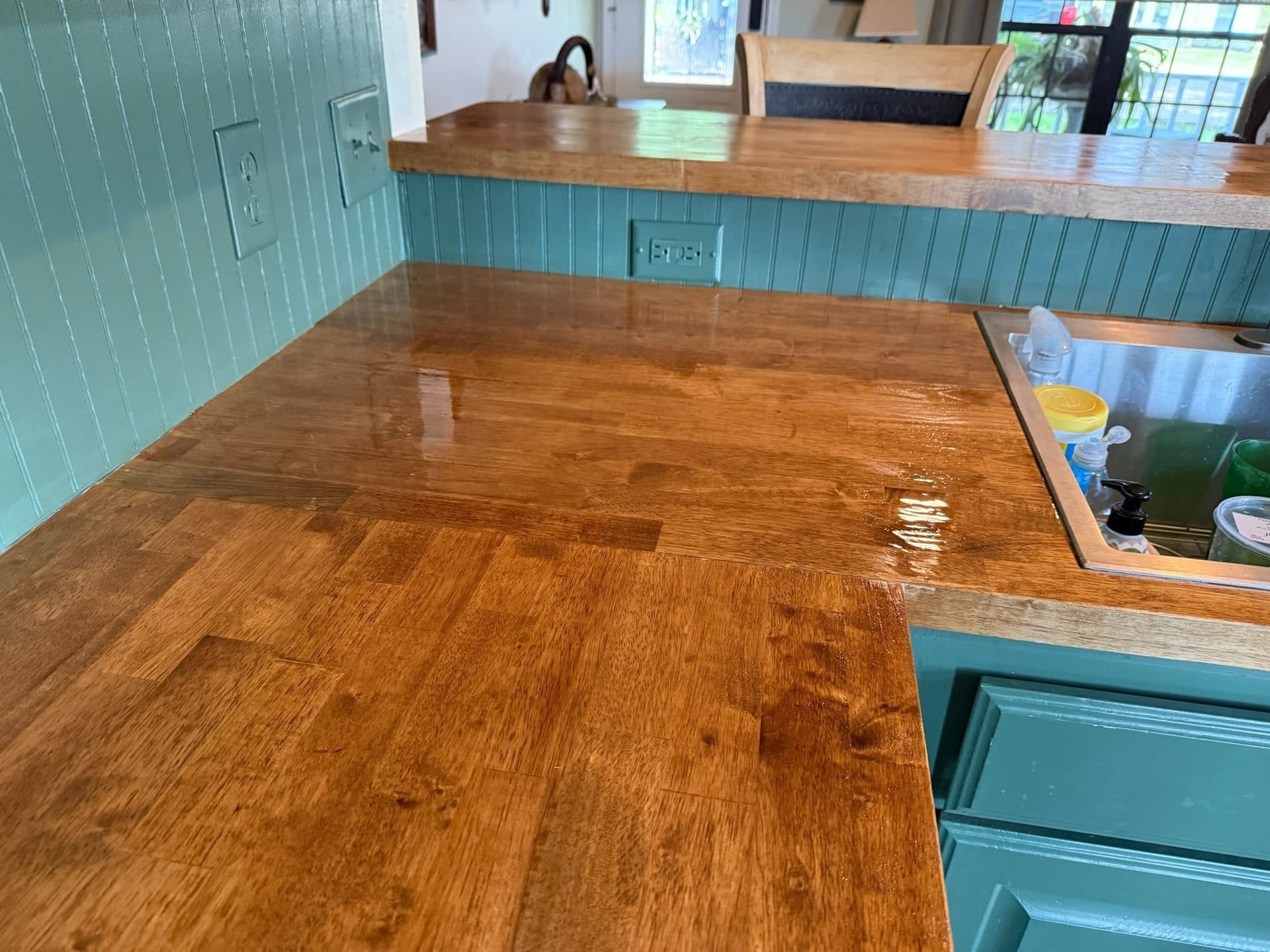Close-up of oiled oak butcher block finish with teal cabinet base