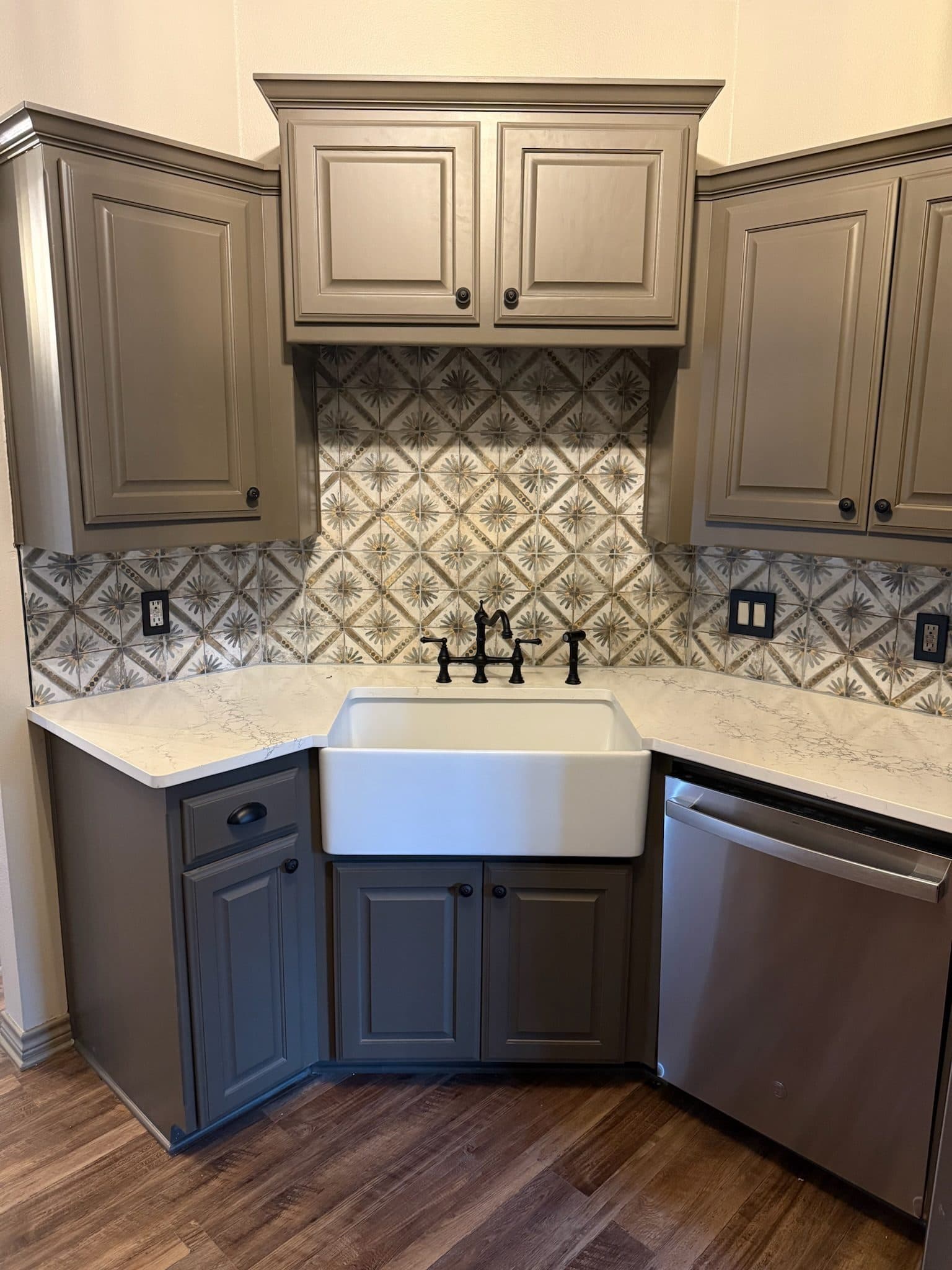 Taupe shaker kitchen corner with white farmhouse sink and patterned tile backsplash