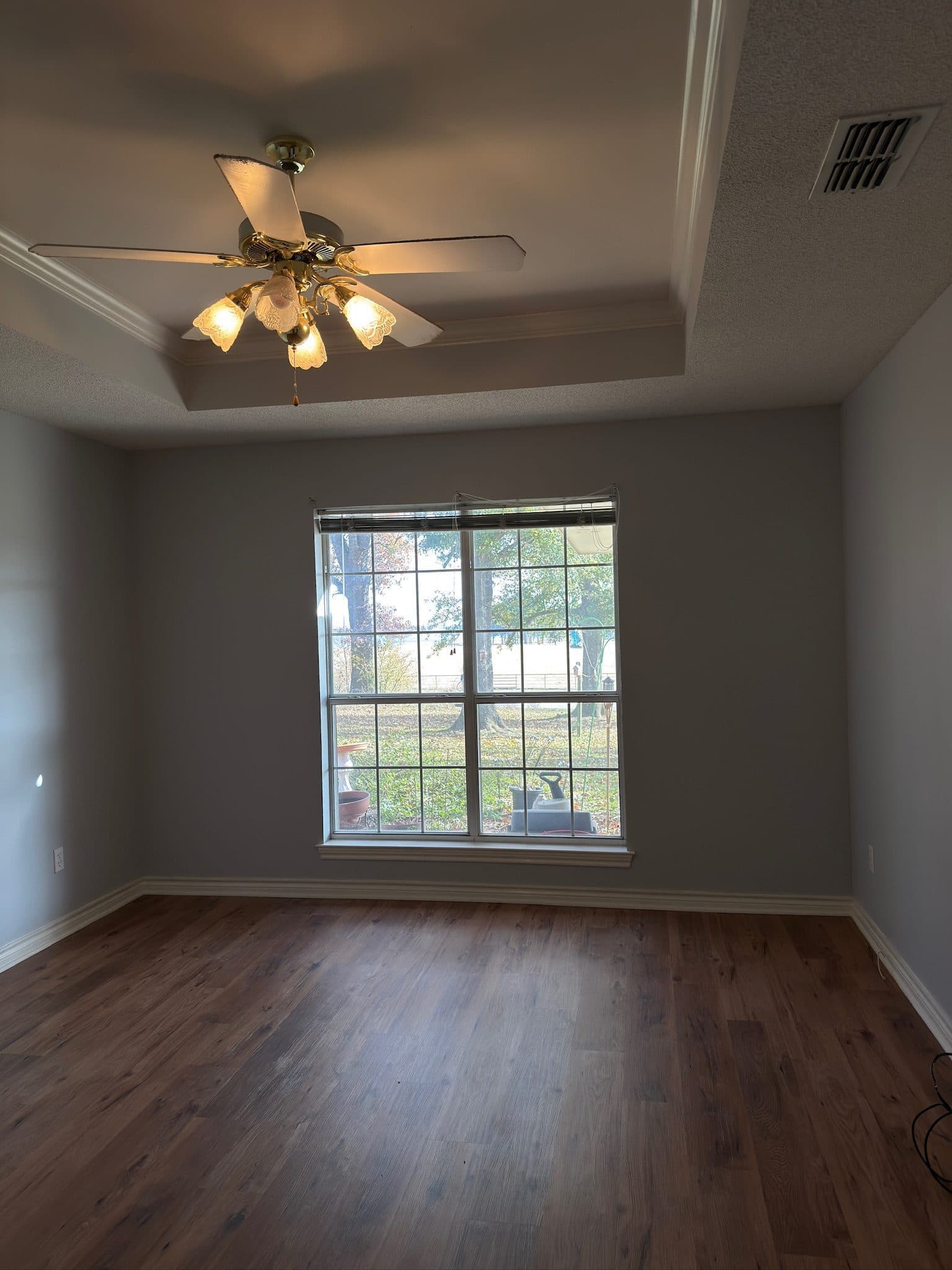 Primary bedroom with bay window and tray ceiling after refresh
