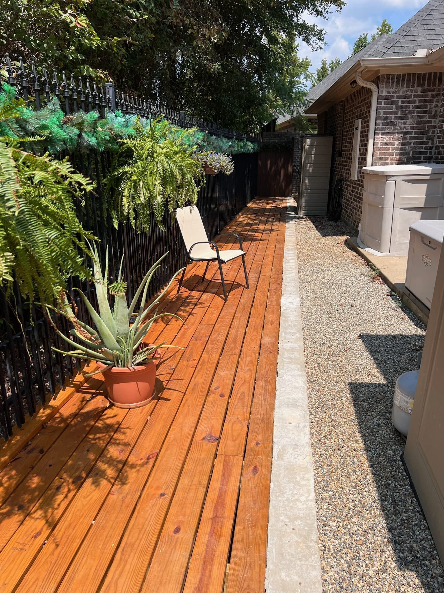 Long stained side-yard wood deck with side planters and patio